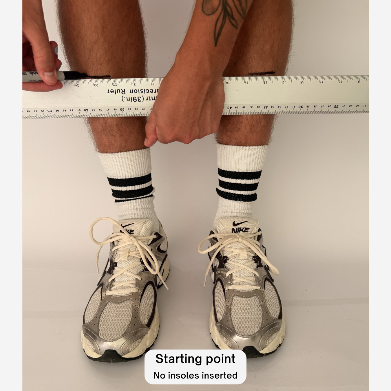 A person's legs and feet are shown wearing white Nike running shoes and white crew socks with black stripes, while a measuring tape is placed around the calf area. A text label at the bottom reads 'Draw the lines'.
