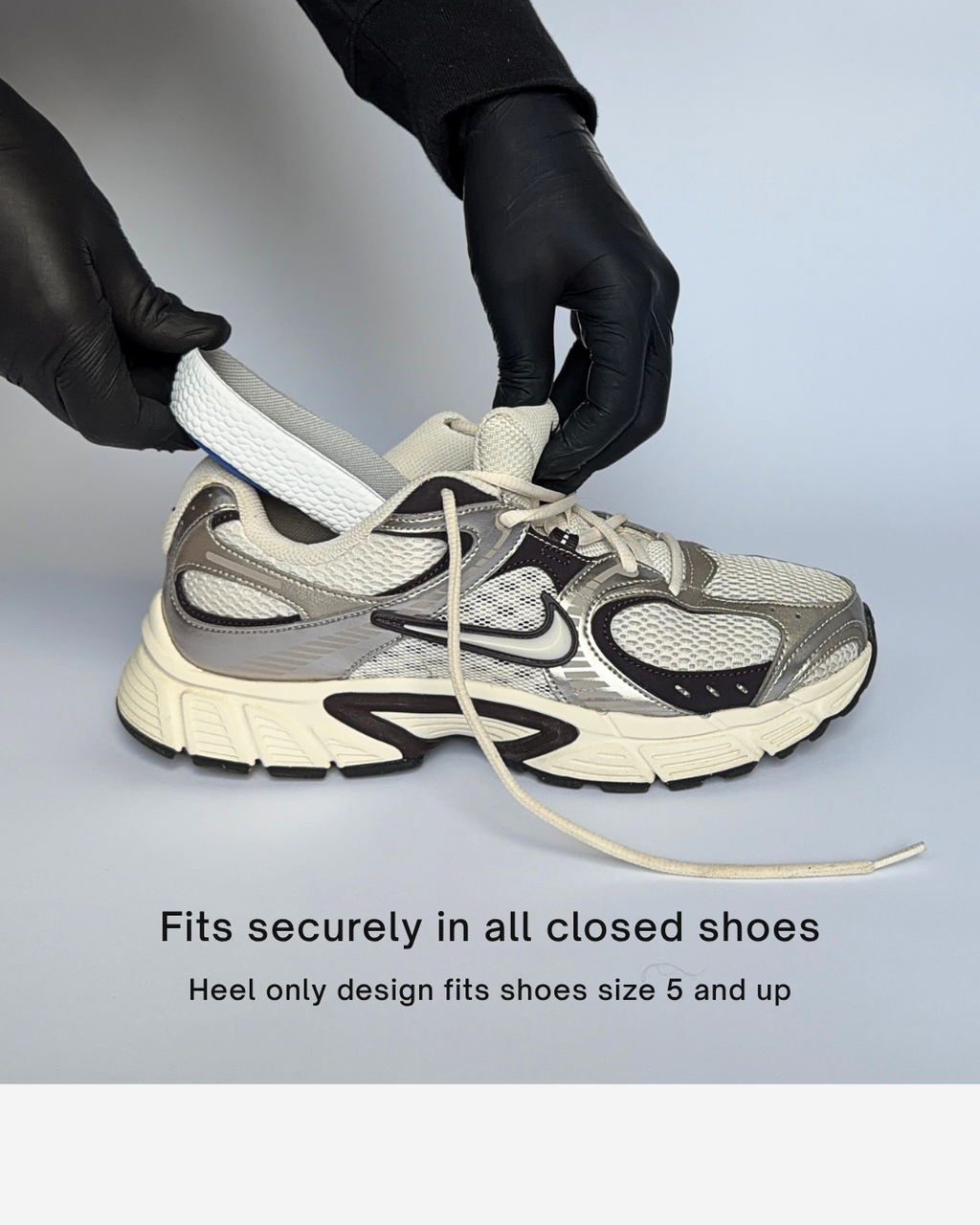 A white, gray, and black athletic sneaker with a heel-only design being demonstrated with a white Öndörq Elevate Invisible height Insole for men inserted into the toe area, shown on a light blue background with text stating 'Fits securely in all closed shoes' and 'Heel only design fits shoes size 5 and up'.