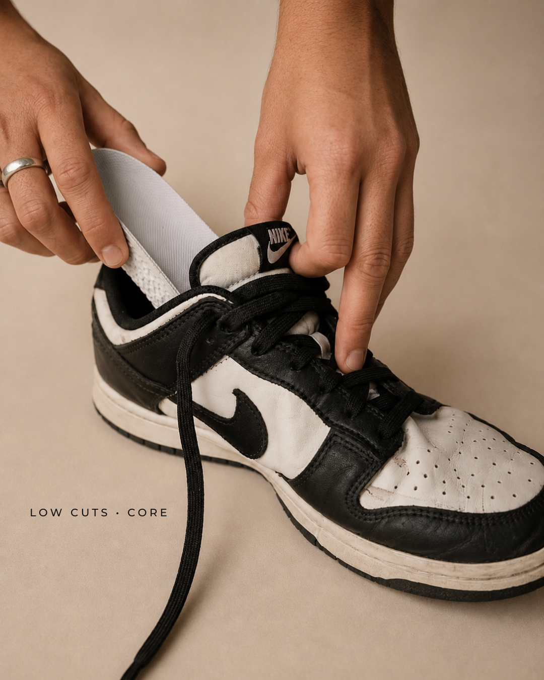 ÖNDÖRQ Elevate Core insoles being inserted into black and white low-cut trainers